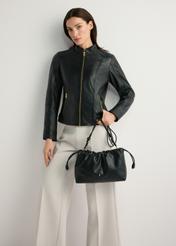 Czarna torebka typu worek TOREC-1215-99(W26) - widok produktu z przodu, trzymanego przez modelkę w ręku, na jasnym tle. Widoczna cała sylwetka.