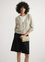 Mała beżowa skórzana torebka damska TORES-1044-1B(W26) - widok produktu z przodu, na modelce, na jasnym tle. Widoczna sylwetka do połowy.