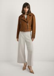 Skórzana kurtka ramoneska w kolorze koniaku KURDS-0610-1F(W26), widok produktu z przodu na modelce. Widoczna cała sylwetka.