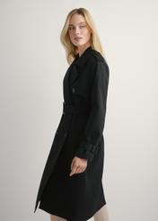 Długa czarna kurtka damska w formie płaszcza KURDT-0512-99(W25), widok produktu od boku na modelce, widoczna połowa sylwetki.