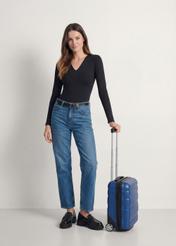 Walizka kabinowa na kółkach WALPC-0012-69-16(W25), widok produktu skosem przy modelce, widoczna cała sylwetka.