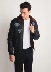 Brązowy kożuch męski w stylu pilotki KOZMP-0007-90(Z25) - widok produktu z przodu na modelu na białym tle. Widoczna sylwetka do kolan.