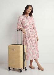 Walizka średnia na kółkach WALAB-0083-2B-24(W26), widok produktu skosem obok sylwetki modelki.