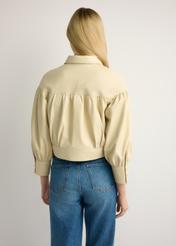 Skórzana jasnożółta kurtka damska KURDS-0574-2A(W26), widok produktu z tyłu na modelce. Widoczna połowa sylwetki.