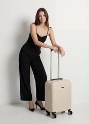 Walizka mała na kółkach WALAB-0040-0C-19(W26), widok produktu od przodu przy modelce, widoczna cała sylwetka.