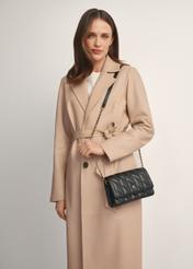 Mała pikowana torebka damska w kolorze czarnym TOREC-1150-99(W26), widok produktu od przodu na modelce, widoczna połowa sylwetki.