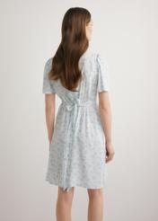 Krótka sukienka damska w kwiaty SUKDT-0276-7P(W26), widok produktu z tyłu na modelce. Widoczna połowa sylwetki.