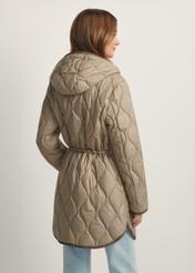 Ciemnobeżowa pikowana kurtka damska KURDT-0654-1B(W26), widok produktu z tyłu na modelce. Widoczna połowa sylwetki.