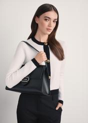 Elegancka czarna torebka damska TOREC-1068-99(Z25) - widok produktu po skosie na modelce, na białym tle. Widoczna połowa sylwetki bokiem.