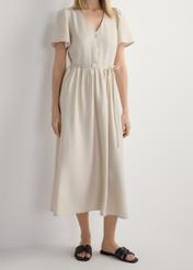 Czarne skórzane klapki damskie z plecionką BUTYD-1225-99(W26), widok produktu z przodu na stopach modelki, na białym tle. Widoczna połowa sylwetki.