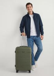 Walizka średnia na kółkach WALAB-0040-55-24(W25), widok produktu od przodu przy modelce, widoczna cała modelka.