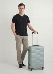 Walizka średnia na kółkach WALAB-0081-8F-24(W26), widok produktu skosem obok sylwetki modelki.