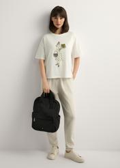 Czarny nylonowy plecak damski TOREN-0341-99(W26), widok produktu w dłoni modelki. Widoczna cała sylwetka.