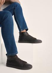 Brązowe skórzane buty sportowe męskie BUTYM-0520-89(Z25) - widok produktu z boku na modelu na białym tle. Widoczna sylwetka do kolan.