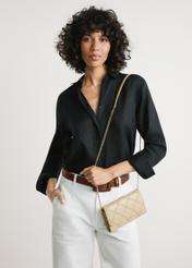 Mała beżowa skórzana torebka damska TORES-1043-1B(W26) - widok produktu z przodu, na modelce, na jasnym tle. Widoczna sylwetka do kolan. 