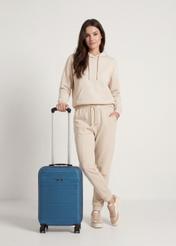 Walizka mała na kółkach WALAB-0040-7H-19(W26), widok produktu od przodu przy modelce, widoczna cała sylwetka.