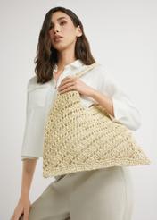 Beżowa torebka damska ze słomki naturalnej TOREC-1220-1E(W26) - widok produktu od dołu, lekko po skosie, na jasnym tle. Widoczna połowa sylwetki. 