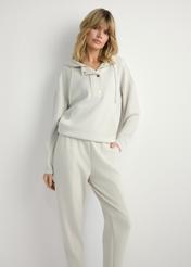 Jasnobeżowa bluza damska z kapturem BLZDT-0111A-1A(W26), widok produktu z przodu na modelce. Widoczna połowa sylwetki.