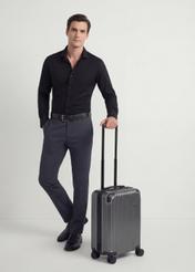 Walizka mała na kółkach WALAB-0073-9C-19(W26), widok produktu skosem obok sylwetki modela.