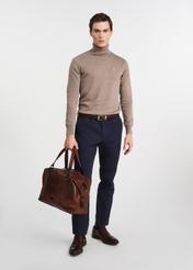 Brązowa skórzana duża torba męska TORMS-0103-1H(W26), widok produktu w dłoni modela, na jasnym tle.