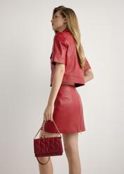 Mała pikowana torebka damska w kolorze czerwonym TOREC-1150-4B(W26), widok produktu od przodu na modelce, widoczna połowa sylwetki.