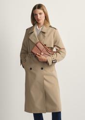 Brązowa torebka listonoszka damska TOREC-1137-1F(W26)- widok produktu z przodu, na modelce, na jasnym tle. Widoczna sylwetka do kolana.