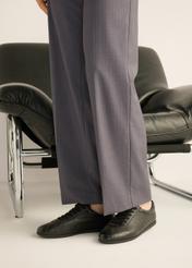 Czarne skórzane sneakersy damskie BUTYD-1293-9I(Z26), widok produktu z boku na stopach modelki.