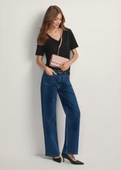 Różowa mała pikowana torebka damska TOREC-1033-5A(W26) - widok produktu z przodu, na modelce, na jasnym tle. Widoczna cała sylwetka.