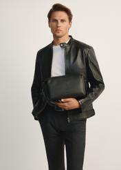 Duża czarna kosmetyczka męska TORMS-0475-99(Z25), widok produktu od przodu na modelu, widoczna połowa sylwetki.