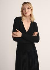 Czarny sweter damski z wiązaniem SWEDT-0234-99(Z25), widok produktu z przodu na modelce. Widoczna połowa sylwetki.