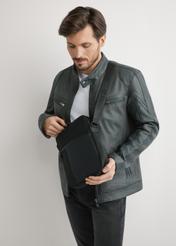 Męska torba miejska w kolorze czarnym TORMN-0402-99(W26) - widok produktu lekko po skosie, trzymanego przez modela w ręku. Widoczna połowa sylwetki. 