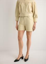 Skórzane jasnożółte szorty damskie SPODS-0035-2A(W26), widok produktu od przodu na modelce, widoczna połowa sylwetki.