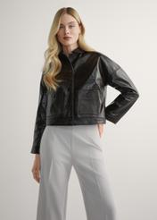 Brązowa skórzana krótka kurtka damska KURDS-0593-1I(W26) - widok produktu z przodu, na modelce, na jasnym tle. Widoczna sylwetka do kolan. 