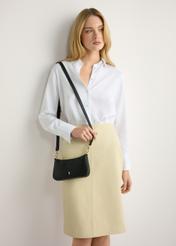 Mała czarna torebka damska TOREC-1188-99(W26) - widok produktu z przodu, na modelce, na jasnym tle. Widczona sylwetka do połowy. 