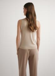 Beżowa bluzka z wełny i jedwabiu BLUDT-0209-1B(W26) - widok produktu z tyłu, na modelce, na jasnym tle. Widoczna sylwetka do kolan.