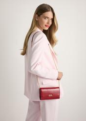 Czerwona skórzana torebka kopertówka TORES-1215-4B(W26), widok produktu od przodu na modelce, widoczna połowa sylwetki.