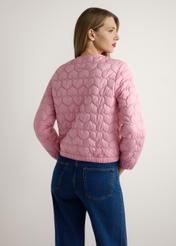Różowa pikowana kurtka damska KURDT-0630-5B(W26), widok produktu od tyłu na modelce, widoczna połowa sylwetki.