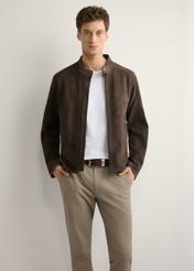 Brązowa zamszowa kurtka męska KURMS-0396-1I(W26) - widok produktu z przodu, na modelu, na jasnym tle. Widoczna połowa sylwetki. 