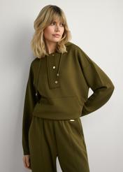 Bluza damska khaki z kapturem BLZDT-0111A-8D(W26), widok produktu z przodu na modelce. Widoczna połowa sylwetki.