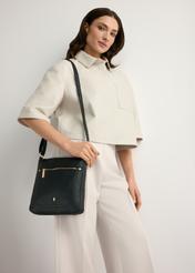 Czarna listonoszka damska z imitacji skóry TOREC-1177-99(W26), widok produktu od przodu na modelce, widoczna połowa sylwetki.