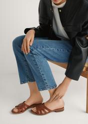 Skórzane klapki damskie w kolorze koniaku BUTYD-1266-1F(W26), widok produktu z boku na stopach modelki, na jasnym tle.