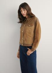 Beżowa skórzana kurtka damska KURDS-0572-1B(W26) - widok produktu z boku, na jasnym tle. Widoczna połowa sylwetki.