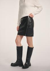 Czarna skórzana spódnica mini SPCDS-0079-3206(Z25) - widok produktu z boku na modelce na białym tle. Widoczna połowa sylwetki. 