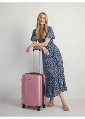 Walizka średnia na kółkach WALAB-0053-5C-24(W26), widok produktu skosem obok sylwetki modelki.