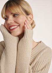 Beżowy sweter dekolt V damski SWEDT-0162-80(Z25), produkt widoczny z boku na modelce, zbliżenie na twarz i dłonie modelki.
