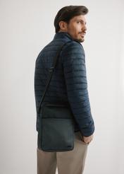 Czarna torba męska crossbody TORMN-0395-9J(W26) - widok produktu z przodu, na modelu, na jasnym tle. Widoczna sylwetka do połowy.