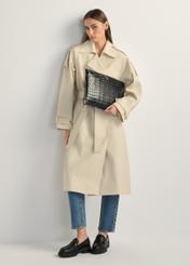 Czarna skórzana teczka damska TORES-0853F-9G(W26) - widok produktu lekko po skosie, na modelce, na jasnym tle. Widoczna cała sylwetka. 