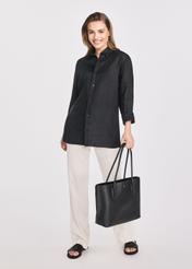 Czarna torebka shopper damska TOREC-0938B-99(Z25), widok produktu w dłoni modelki. Widoczna cała sylwetka.