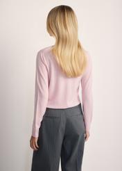 Jasnoróżowy sweter damski SWEDT-0250-34(Z25), widok produktu z tyłu na modelce. Widoczna połowa sylwetki.