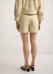 Skórzane jasnożółte szorty damskie SPODS-0035-2A(W26), widok produktu od tyłu na modelce, widoczna połowa sylwetki.